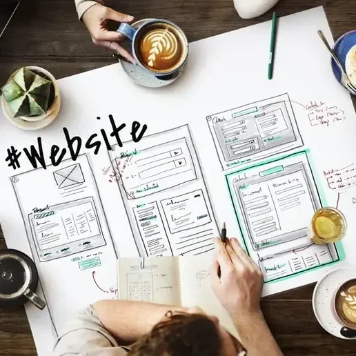 Designers sketching website wireframes on paper over coffee