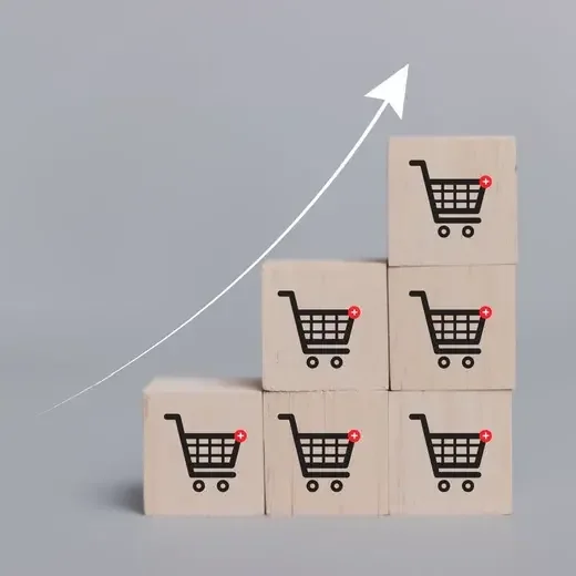Wooden blocks with shopping cart icons stacked into a rising growth curve