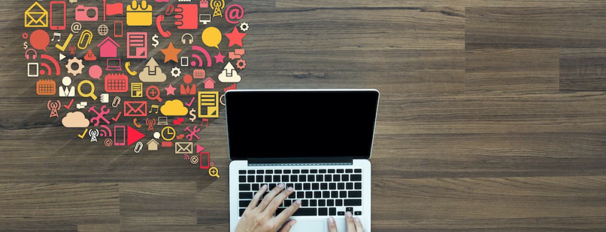 marketer sending out Houston marketing communications on laptop