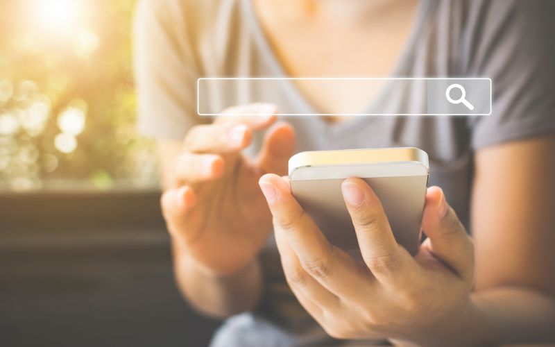 Woman completing a Google search on her phone for a houston marketing and SEO expert