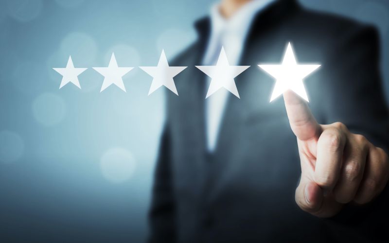 person in a suit submitting a 5 star review for a local business