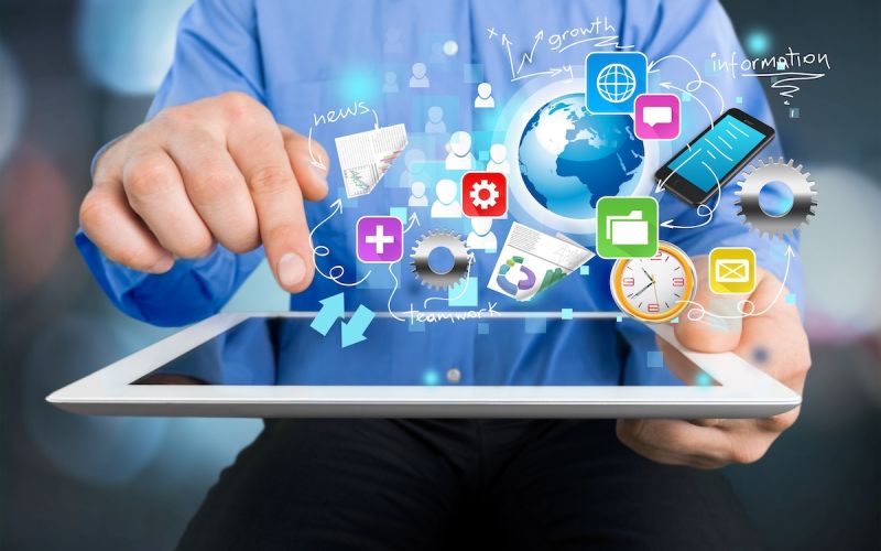 Business owner holding a tablet with various marketing tool logos floating above the screen