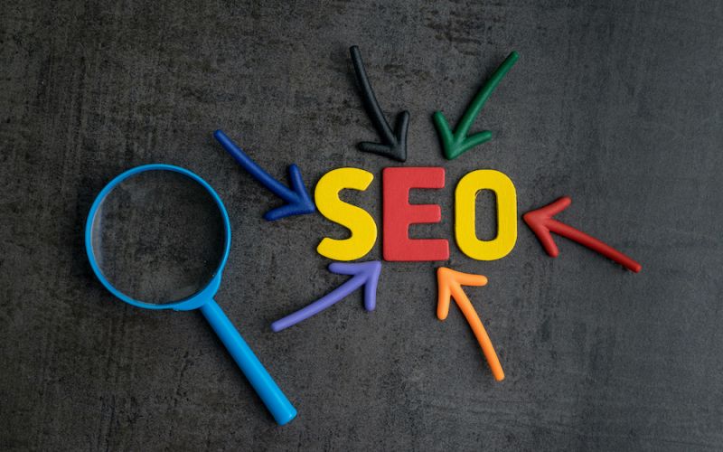 SEO spelled out in color with a magnifying glass