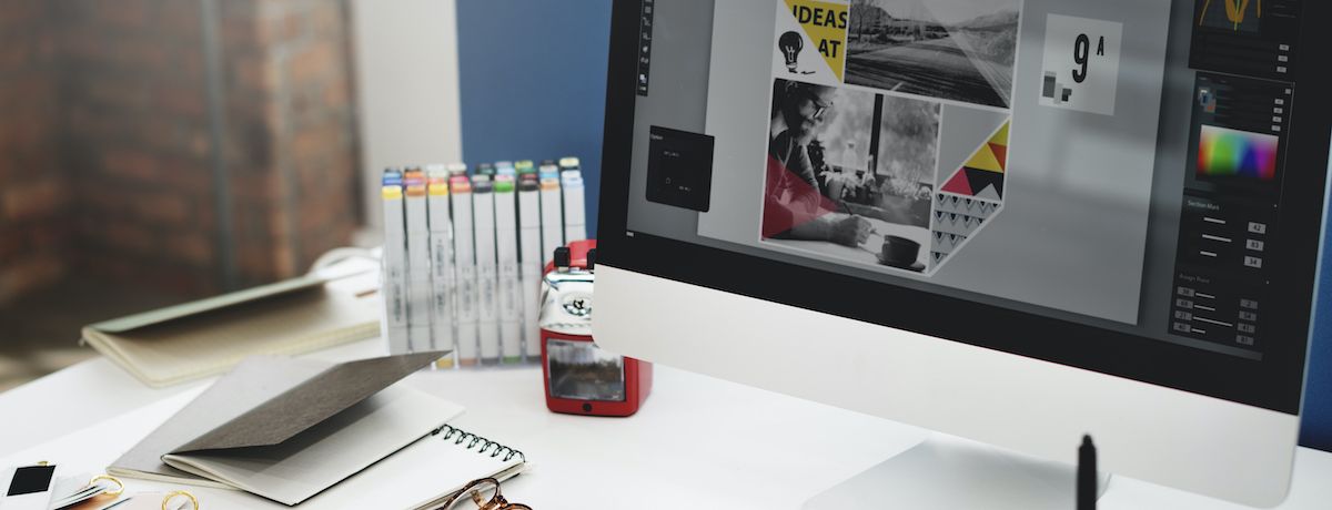 Graphic designer's work set up with software open for marketing graphic work