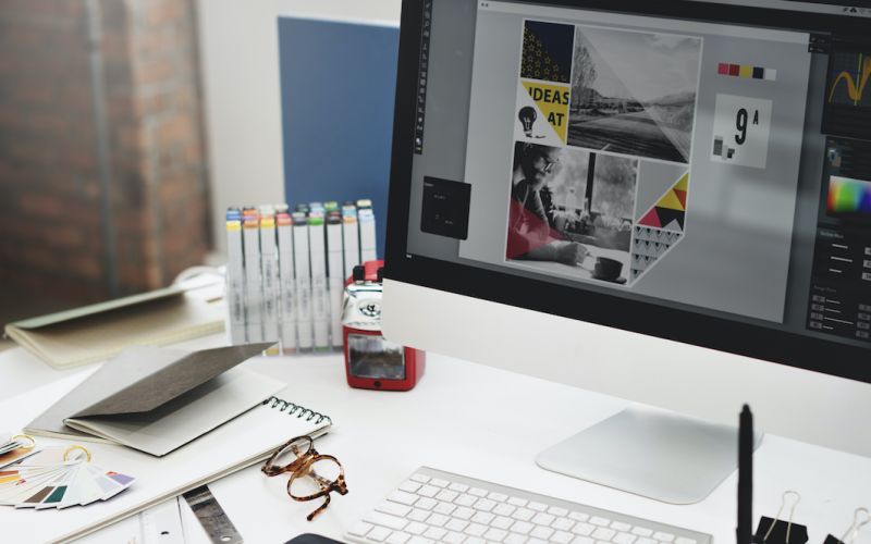 Graphic designer's work set up with software open for marketing graphic work