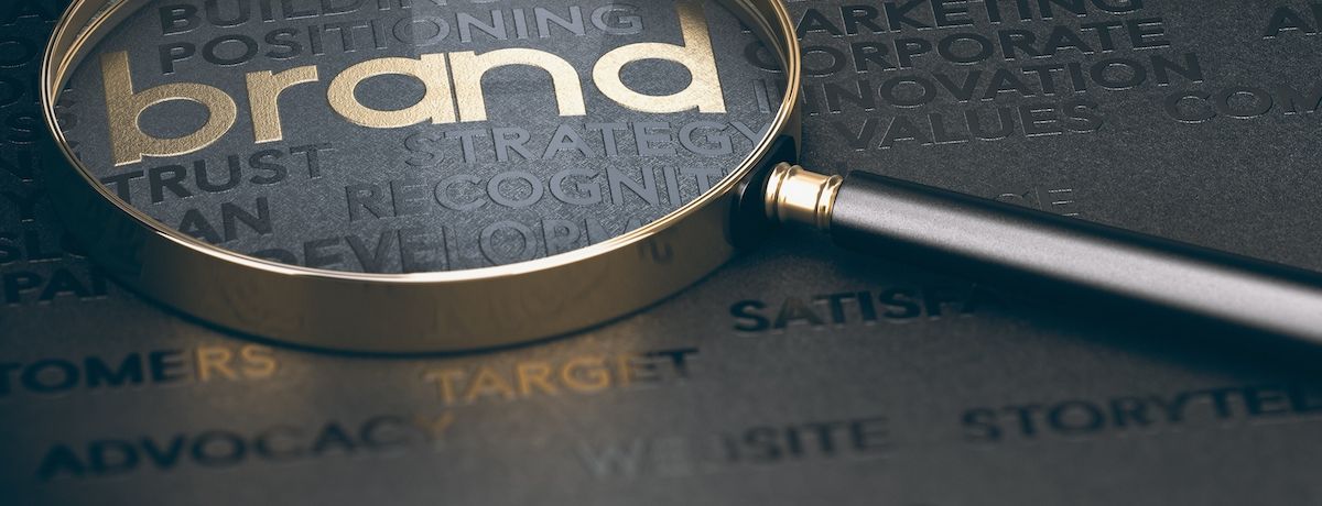 magnifying glass over the word "brand" to signify the importance of creating a brand that stands out