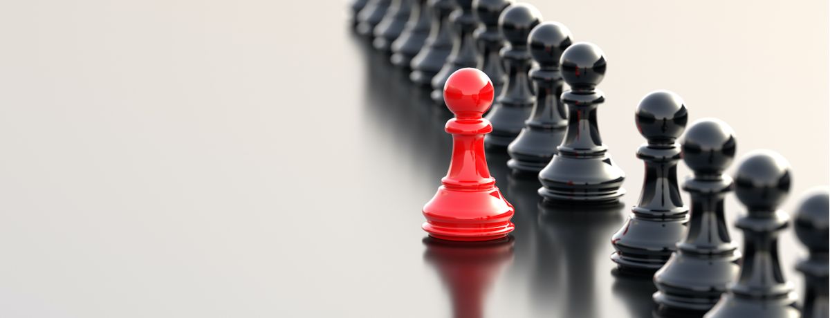 red chess piece standing out from black chess pieces to symbolize standing out from your houston business competition