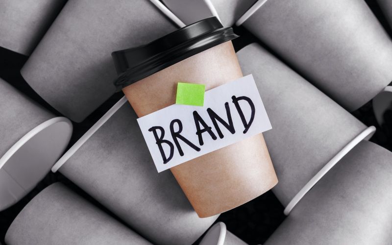 image of a branded coffee cup standing out amongst coffee cups without a brand