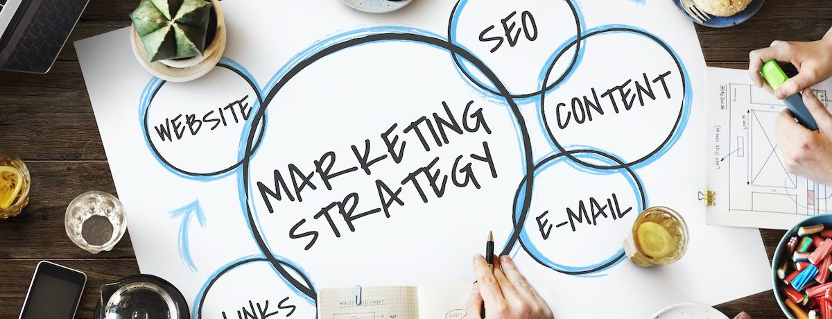 Marketing team surrounding a poster board illustrating different branches of marketing strategy