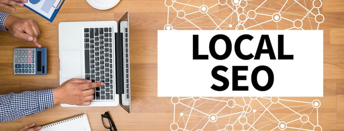 desk with laptop, charts, planning, and a map with local SEO written on top