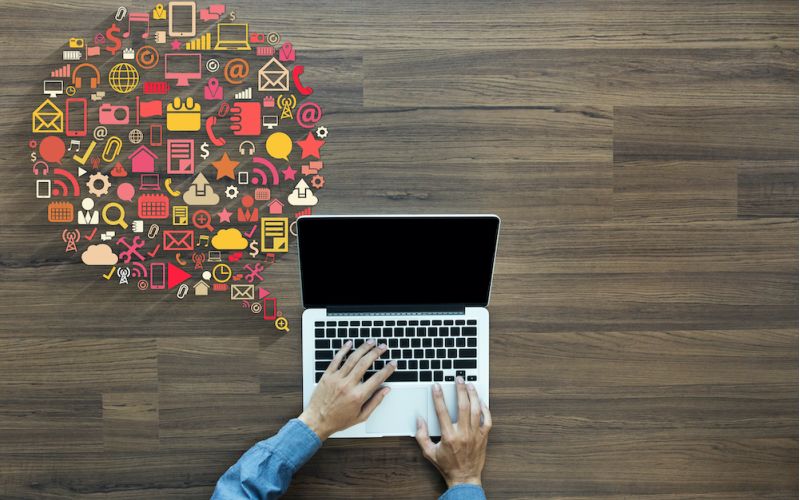 marketer sending out Houston marketing communications on laptop